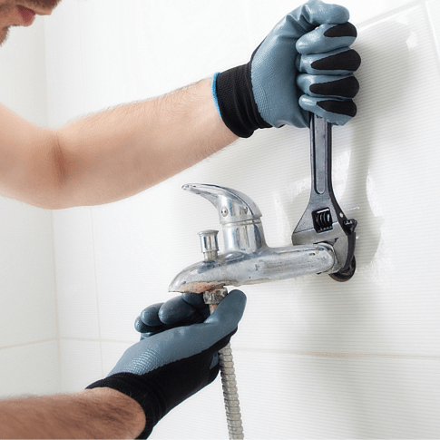 A handyman fixing the faucet - Plumbing Work